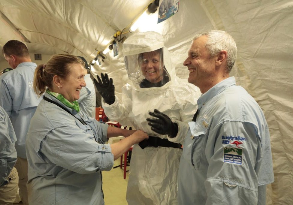 A group of people in a white tent.